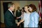 President George W. Bush greets Elizabeth Smart, center, and her mother Lois Smart in the Roosevelt Room Wednesday, April 30, 2003. President Bush met with the Smart family before the signing of the S. 151, PROTECT Act of 2003. White House photo by Eric Draper