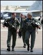 President George W. Bush walks across the tarmac with NFO Lt. Ryan Phillips to Navy One, an S-3B Viking jet, at Naval Air Station North Island in San Diego Thursday, May 1, 2003. Flying to the USS Abraham Lincoln, the President will address the nation and spend the night aboard ship. White House photo by Susan Sterner