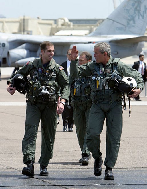 President George W. Bush walks across the tarmac with NFO Lt. Ryan Phillips to Navy One, an S-3B Viking jet, at Naval Air Station North Island in San Diego Thursday, May 1, 2003. Flying to the USS Abraham Lincoln, the President will address the nation and spend the night aboard ship. White House photo by Susan Sterner.