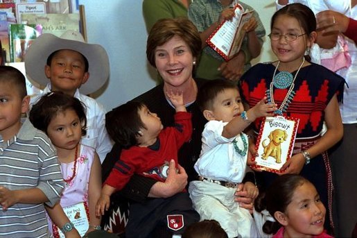 Children at the Kayenta Indian Health Service Clinic crowd around Laura Bush after she reads to them and tours the facility in Kayenta, Arizona, May 8, 2003. White House photo by Susan Sterner