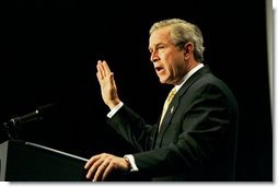 Recalling the experience of watching a Mexican-born Marine take America's oath of citizenship, President George W. Bush raises his right hand as he addresses the National Hispanic Prayer Breakfast in Washington, D.C., Thursday, May 15, 2003.   White House photo by Eric Draper