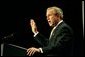 Recalling the experience of watching a Mexican-born Marine take America's oath of citizenship, President George W. Bush raises his right hand as he addresses the National Hispanic Prayer Breakfast in Washington, D.C., Thursday, May 15, 2003.  White House photo by Eric Draper