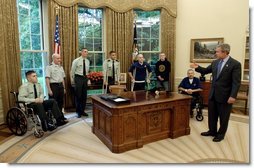 President George W. Bush talks with soldiers after taping his weekly radio address in the Oval Office Friday, May 16, 2003. Honoring Armed Forces Day on May 17th, the President invited soldiers to attend the recording of the address.  White House photo by Eric Draper