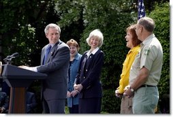 President George W. Bush discusses his plan for wildfire prevention and forest stewardship, the Healthy Forests Initiative, in The East Garden Tuesday, May 20, 2003. Standing on stage with the President are, from left, Agriculture Secretary Veneman, Interior Secretary Gale Norton, Fire Management Officer Andrea Gilham and Wildlife and Fire Staff Officer Rex Mann.  White House photo by Susan Sterner