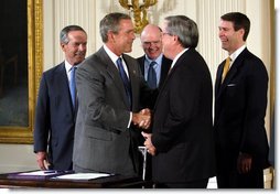 President George W. Bush shakes the hand of Congressman Bill Thomas, R-Calif., after signing the Jobs and Growth Tax Reconciliation Act of 2003 in the East Room Wednesday, May 28, 2003. Also pictured are, from left, Secretary of Commerce Donald Evans, Secretary of the Treasury John Snow and Senate Majority Leader Bill Frist, R-Tenn.  White House photo by Eric Draper