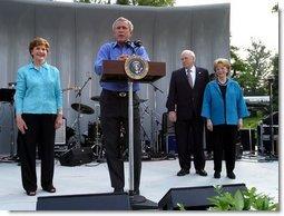 President George W. Bush shares the stage with Laura Bush, Vice President Dick Cheney and Lynne Cheney as he welcomes members of Congress and their families to the Congressional Picnic on the South Lawn Wednesday, June 18, 2003.  White House photo by Susan Sterner