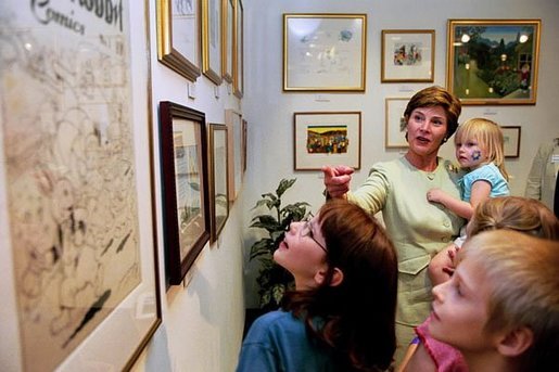 Laura Bush leads a group of children through an impromptu tour of an exhibit of illustrations from children's book on display at the Creative Discovery Museum in Chattanooga, Tenn., June 20, 2003. White House photo by Susan Sterner.