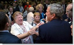President George W. Bush reacts to a kiss by a senior citizen after speaking about pending Medicare legislation at the Little Havana Activities and Nutrition Center in Miami, Fla., June 30, 2003.  White House photo by Paul Morse