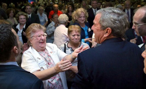 President George W. Bush reacts to a kiss by a senior citizen after speaking about pending Medicare legislation at the Little Havana Activities and Nutrition Center in Miami, Fla., June 30, 2003. White House photo by Paul Morse