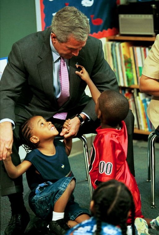 During a tour of Highland Park Elementary School in Landover, Md., President George W. Bush plays with children at the school's Head Start Center where he discussed strengthening America's Head Start Program Monday, July 7, 2003. White House photo by Paul Morse