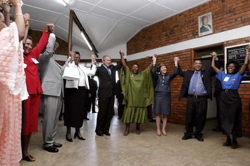 President George W. Bush, Mrs. Laura Bush, and to the President's right, Ugandan President Yoweri Museveni and Mrs. Museveni sing along with a choir and staff members of The AIDS Support Organization (TASO) Centre in Entebbe, Uganda Friday, July 11, 2003. White House photo by Susan Sterner.
