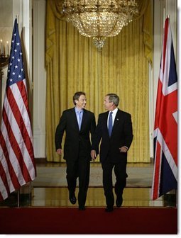 President George W. Bush and British Prime Minister Tony Blair walk through the Cross Hall of the White House before the start of their news conference, Thursday, July 17, 2003.  White House photo by Paul Morse