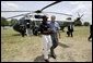 President George W. Bush walks with YMCA volunteer Andrew Simpson after arriving on Marine One in Dallas, Texas, Friday, July 18, 2003. White House photo by Paul Morse