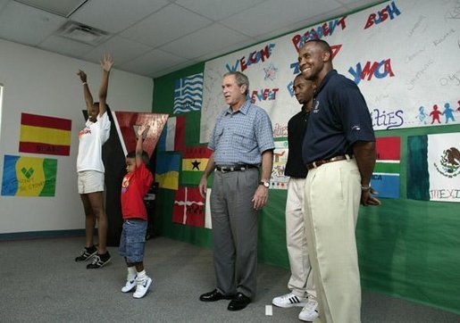 President George W. Bush watches an exercise class during a tour of Lakewest Family YMCA in Dallas, Texas, Friday, July 18, 2003. Also pictured, at far right, are Lynn Swann, Chairman of the PresidentÕs Council on Physical Fitness and Sports and YMCA Volunteer Andrews Simpson. White House photo by Paul Morse.