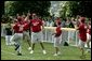 Coaches cheer their fellow teammate after he hit a home-run ball out of the park during a game in the White House South Lawn Tee-Ball League Sunday, July 27, 2003. White House photo by Lynden Steele.