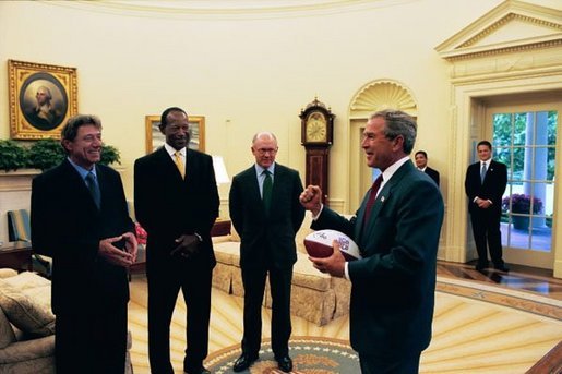 During the presentation of the official NFL football of the 2003 season, President George W. Bush talks with former New York Jets quarterback Joe Namath, Executive Director of the NFL Players Association Gene Upshaw, and New York Jets team owner Woody Johnson in the Oval Office Tuesday, Sept. 2, 2003. The Washington Redskins play the New York Jets Thursday. White House photo by Tina Hager.