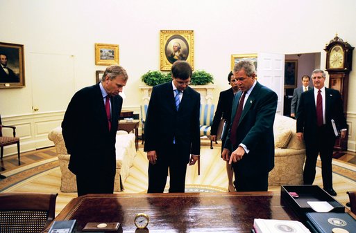 President George W. Bush points to the carved Presidential Seal on the historic Resolute Desk during a meeting with Prime Minister Jan Peter Balkenende, center, and Minister of Foreign Affairs Jaap de Hoop Scheffer of the Kingdom of the Netherlands in the Oval Office Wednesday, Sept. 3, 2003. White House photo by Tina Hager.
