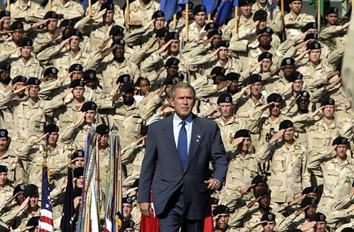 President George W. Bush walks on stage before addressing military personnel and their families at Ft. Stewart, Ga., Friday, Sept. 12, 2003. White House photo by Paul Morse