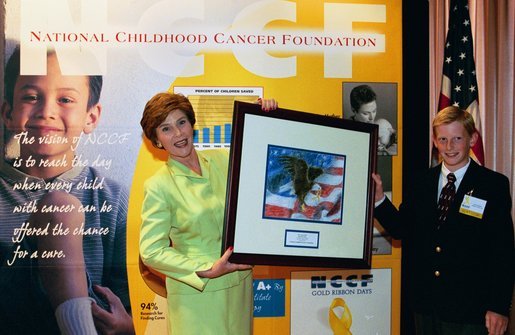 Laura Bush accepts a painting from Hunter Nelson, 14, a childhood cancer survivor, at the Opening Ceremony for the National Childhood Cancer Foundation's Gold Ribbon Days 2003. Mrs. Bush was the Keynote Speaker at the event, which is held annually to raise awareness and support of childhood cancer issues. Mrs. Bush offered her congratulations and support to patients, parents, doctors, nurses and medical researchers living and working every day to conquer the nation's #1 disease killer of America's children: cancer. The name of the event is derived from the Gold Ribbon, the symbol of childhood cancer awareness; the Opening Ceremony was held at the Reserve Officers Association in Washington, D.C. White House photo by Susan Sterner