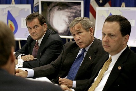 Sitting with Homeland Security Secretary Tom Ridge, left, and Under Secretary Mike Brown of FEMA, President George W. Bush receives a briefing on the damage inflicted by Hurricane Isabel during a tour of the temporary operations center at the Virginia State Police Academy in Richmond, Va., Monday, Sept. 22, 2003. White House photo by Paul Morse.