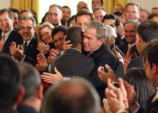 President George W. Bush embraces Brazilian Musician Alexandre Pires after his performance during the Celebration of Hispanic Heritage Month in the East Room, Thursday, Oct 2, 2003. White House photo by Tina Hager.