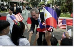 President George W. Bush, Philippine President Gloria Arroyo and Laura Bush greet school children during a welcoming ceremony at Malacanang Palace in Manila, Philippines, Saturday, Oct. 18, 2003.  White House photo by Paul Morse