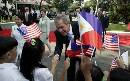 President George W. Bush, Philippine President Gloria Arroyo and Laura Bush greet school children during a welcoming ceremony at Malacanang Palace in Manila, Philippines, Saturday, Oct. 18, 2003. White House photo by Paul Morse