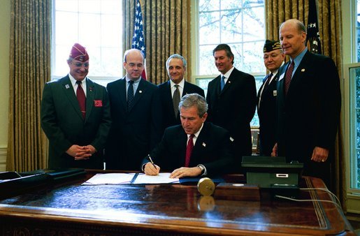 President George W. Bush signs H.R. 3365, The Military Family Tax Relief Act of 2003 in the Oval Office on Veterans Day, Nov. 11, 2003. The legislation provides tax-relief for military and Foreign Service personnel. Pictured with the President are, from left: John Brieden, American Legion National Commander; Congressman James McGovern, R-Mass.; Congressman Rick Renzi, R-Ariz.; Secretary of Veterans Affairs Anthony Principi; Jim Mueller, Veterans of Foreign Wars, Junior Vice Commander-in-Chief; and Admiral Norb Ryan, Military Officers Association of America. White House photo by Eric Draper.