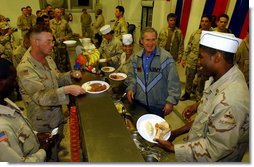 President George W. Bush meets with troops and serves Thanksgiving Dinner at the Bob Hope Dining Facility, Baghdad International Airport, Iraq,, Thursday, November 27, 2003.  White House photo by Tina Hager