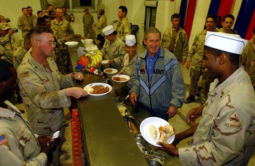 President George W. Bush meets with troops and serves Thanksgiving Dinner at the Bob Hope Dining Facility, Baghdad International Airport, Iraq,, Thursday, November 27, 2003. White House photo by Tina Hager.