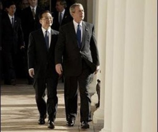 After the Arrival Ceremony, President George W. Bush and Premier Wen Jiabao of China walk along the Rose Garden Colonnade on their way to the Oval Office Tuesday, Dec. 9, 2003. "We're going to have extensive discussions today on a lot of issues," said the President during an Oval Office meeting with the media. "We've just had a very friendly and candid discussion. There's no question in my mind that when China and the United States works closely together we can accomplish a lot of very important objectives." White House photo by Paul Morse.