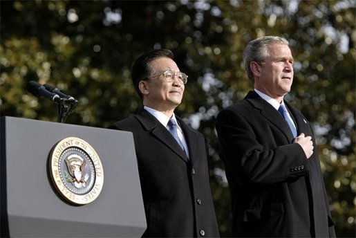 President George W. Bush and Premier Wen Jiabao of China stand for the playing their national anthems during an Arrival Ceremony on the South Lawn Tuesday, Dec. 9, 2003. White House photo by Paul Morse