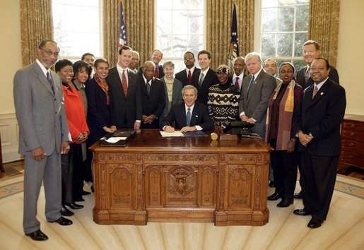 President George W. Bush signs H. R. 3491, the National Museum of African-American History and Culture Act, in the Oval Office Tuesday, Dec. 16, 2003. The act authorizes the creation of a Smithsonian Institution museum dedicated to the legacy of African Americans in America. White House photo by Paul Morse.