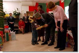 President George W. Bush and Laura Bush take part in the Angel Tree Family Christmas at Shiloh Baptist Church in Alexandria, Va., Monday, Dec. 22, 2003. Began in 1982 by Prison Fellowship, the program helps provides Christmas gifts to children who has an incarcerated parent.   White House photo by Tina Hager