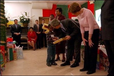 President George W. Bush and Laura Bush take part in the Angel Tree Family Christmas at Shiloh Baptist Church in Alexandria, Va., Monday, Dec. 22, 2003. Began in 1982 by Prison Fellowship, the program helps provides Christmas gifts to children who has an incarcerated parent. White House photo by Tina Hager