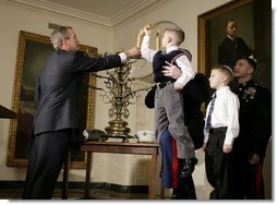 President George W. Bush helps Jacob Murphy light a menorah along with his father Captain Neil Murphy Jr. Wednesday afternoon December 22, 2003 at the White House.  White House photo by Paul Morse