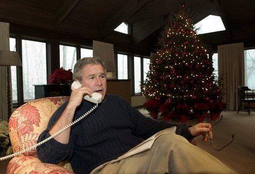 President George W. Bush talks during Christmas Eve telephone calls to members of the Armed Forces at Camp David White House photo by Eric Draper