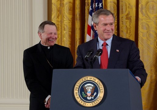 President George W. Bush addresses The National Catholic Educational Association in the East Room Friday, Jan. 9, 2004. The Association represents more than 200,000 educators serving 7.6 million students in Catholic education at all levels. Pictured with the President is His Excellency Gregory Aymond, Bishop of Austin, Texas. White House photo by Tina Hager