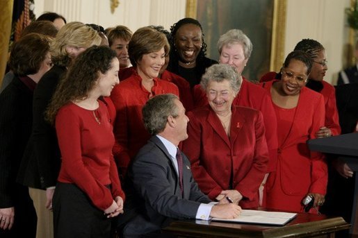 President George W. Bush and Laura Bush laugh with survivors of heart disease as the President signs the American Heart Month proclamation at the White House Monday, Feb. 2, 2004. White House photo by Paul Morse