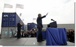 As Homeland Security Secretary Tom Ridge stands nearby, President George W. Bush waves to the audience after delivering remarks on homeland security at the Port of Charleston, S.C., Feb. 5, 2004.  White House photo by Paul Morse