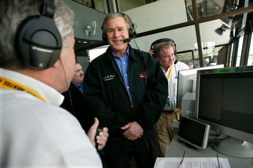 President George W. Bush participates in a live radio interview with Motor Racing Network announcers Joe Moore, left, and Barney Hill at the 46th Annual Daytona 500 in Daytona, Florida, Sunday, Feb. 15, 2004. White House photo by Eric Draper