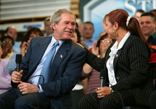 President George W. Bush and accounting clerk Neomi Gonzalez react on stage during a conversation on the economy with employees at Nu-Air Manufacturing Company in Tampa, Florida, Monday, Feb. 16, 2004. White House photo by Eric Draper