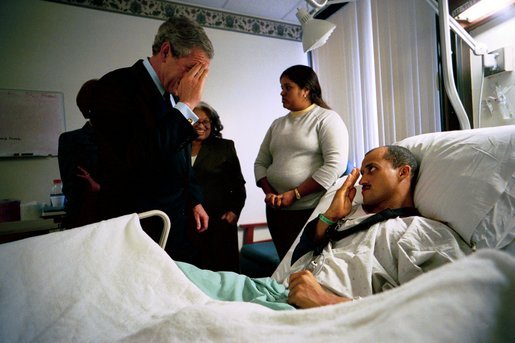 After presenting him The Purple Heart, President George W. Bush salutes U.S. Army Staff Sergeant Santiago Frias of Bronx, N.Y., at Walter Reed Army Medical Center in Washington, D.C., Friday, March 19, 2004. Sgt. Frias was injured while serving in Operation Iraqi Freedom. Also pictured is Sgt. Frias' mother, Cristina DeJesus, left, and his wife, Nejil. White House photo by Eric Draper.
