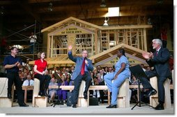 President George W. Bush acknowledges the audience at the conclusion of a conversation on homeownership at the Carpenters Training Center in Phoenix, Ariz., Friday, March 26, 2004. Pictured on stage with the President, from left, are construction foreman Jorge Sotelo, first-time homebuyer Emily McElhaney, first-time homebuyer Monica Sims and Doug McCarron, General President of the United Brotherhood of Carpenters and Joiners of America. White House photo by Eric Draper