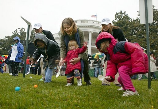 Slipping and sliding, eggs are tossed in rainy race on the South Lawn during the 2004 White House Easter Egg Roll Monday, April 12, 2004. Because of inclement weather, the annual event closed at noon.