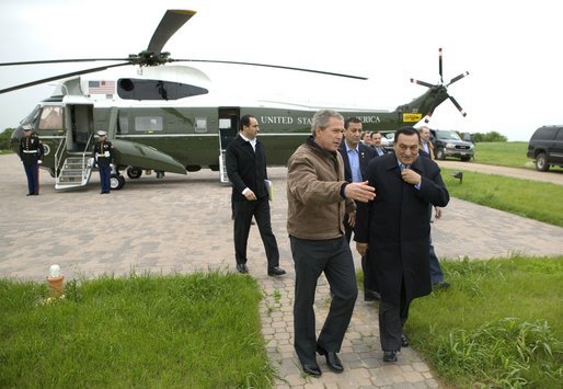 President George W. Bush escorts President Hosni Mubarak of Egypt after his arrival at the Bush Ranch in Crawford, Texas, Monday, April 12, 2004. White House photo by Eric Draper.
