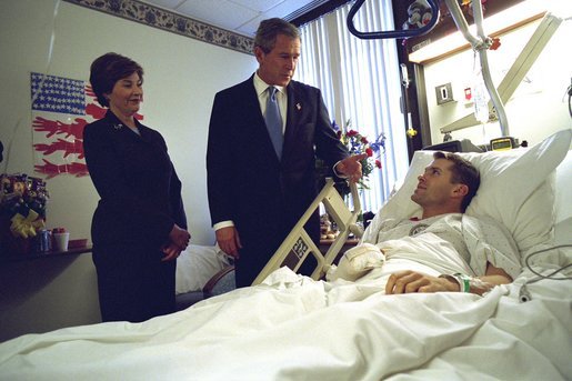 President George W. Bush and Laura Bush visit Army Staff Sergeant Michael McNaughton of Denham Springs, La., at Walter Reed Army Medical Center in Washington, D.C., Friday, Jan. 17, 2003. Sgt. McNaughton was wounded in Afghanistan Jan. 9, 2003. The President and SSgt. McNaughton ran together at the White House Wednesday, April 14, 2004. White House photo by Eric Draper.