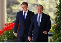 President George W. Bush and Prime Minister Tony Blair walk along the colonnade before a press conference in the Rose Garden of the White House on April 16, 2004.  White House photo by Paul Morse