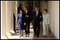 President George W. Bush and Prime Minister Tony Blair walk along the colonnade with their wives Mrs. Laura Bush and Mrs. Cherie Blair after a press conference in the Rose Garden of the White House on April 16, 2004. White House photo by Paul Morse.
