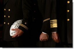 Signed by the entire team as a gift for the President, a football is tucked under the arm of a member of the U.S. Naval Academy football team during the presentation of the Commander-In-Chief Trophy in the East Room Monday, April 19, 2004.  White House photo by Tina Hager